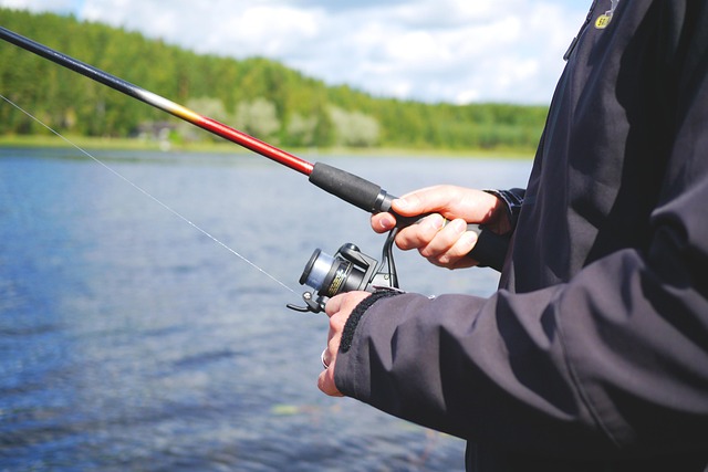 Wędkarz łowi na spinning nad jeziorem
